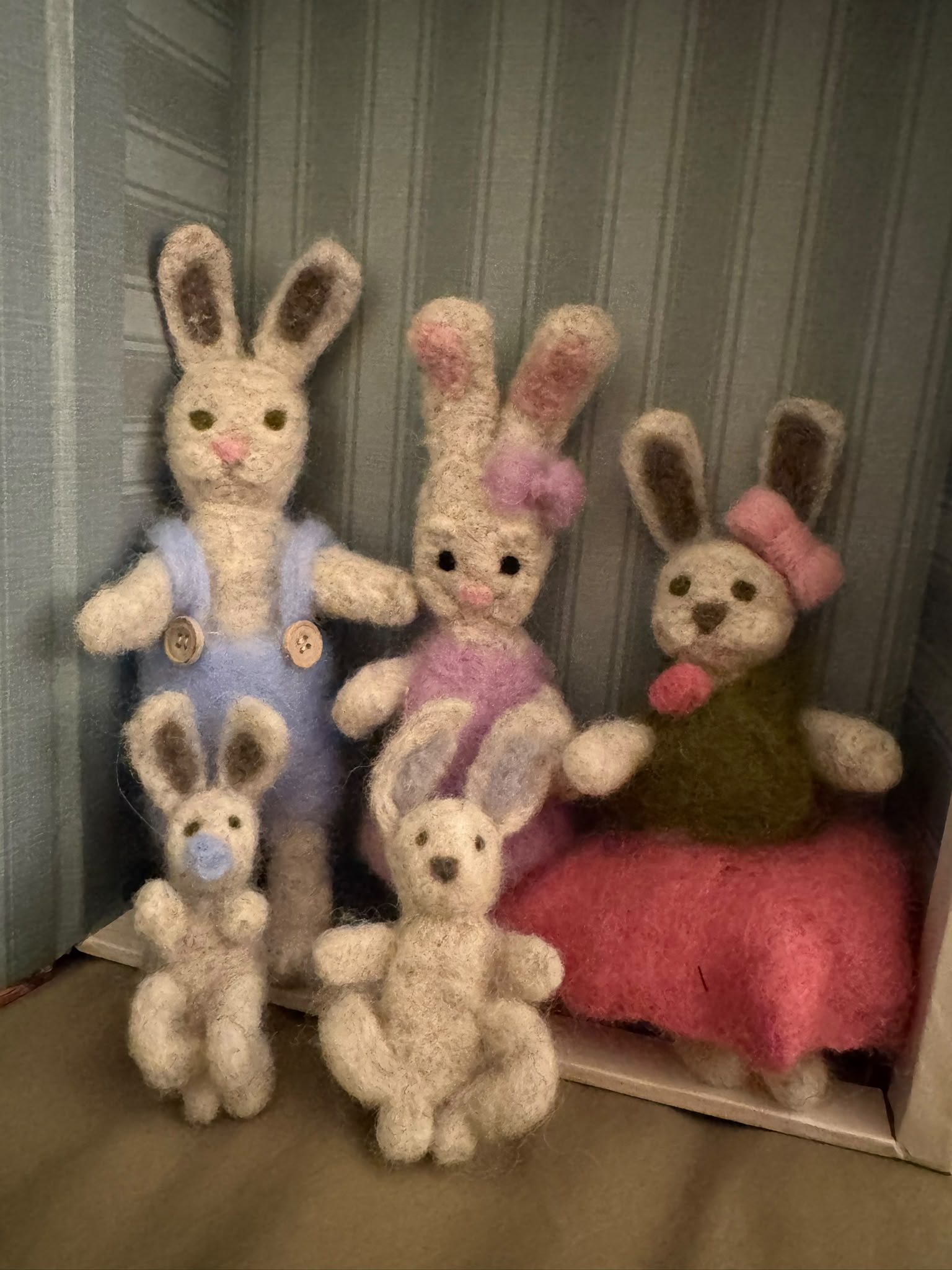Eine handgefilzte Hasenfamilie in warmen Naturfarben